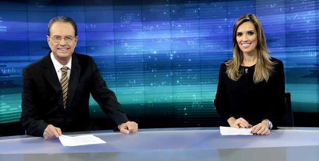 Hermano Henning e Karyn Bravo no cenário do Jornal do SBT, que passará a ser gravado por economia