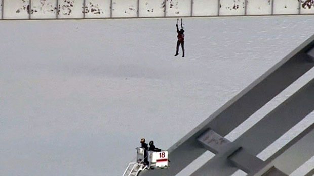 Funcionário ficou pendurado por quase uma hora em um ponte em Houston (Foto: BBC)