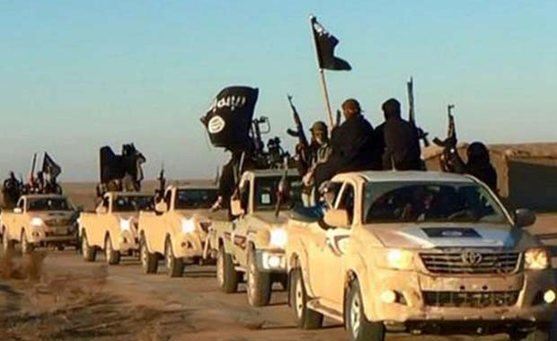 Jihadistas do Estado Islâmico exibem suas armas e bandeiras do grupo em comboio em uma estrada