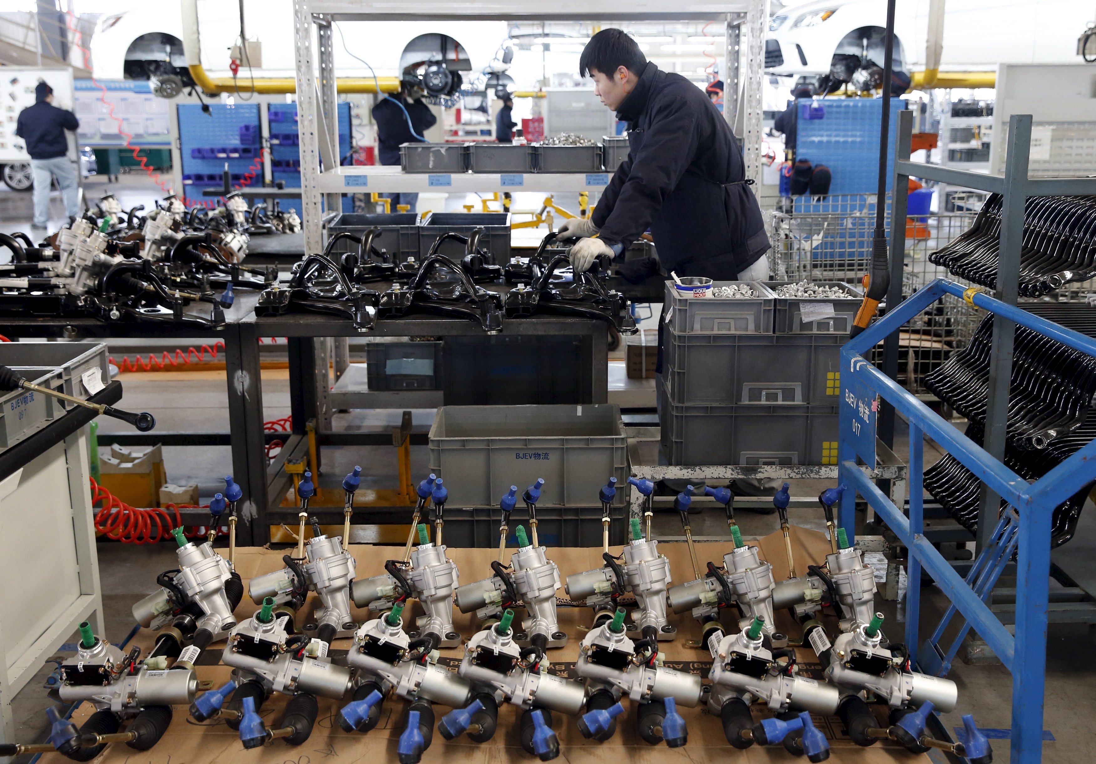 Empregado trabalha em linha de montagem de carros eletrônicos em Pequim (Foto: Kim Kyung-Hoon/Reuters)