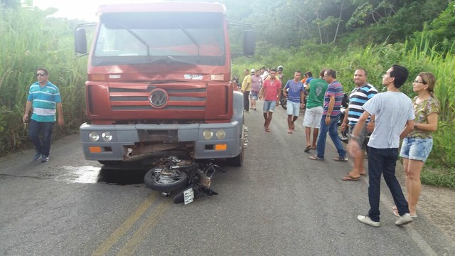 Moto ficou presa embaixo da parte da frente do caminhão (Foto: Reprodução/WhatsApp)