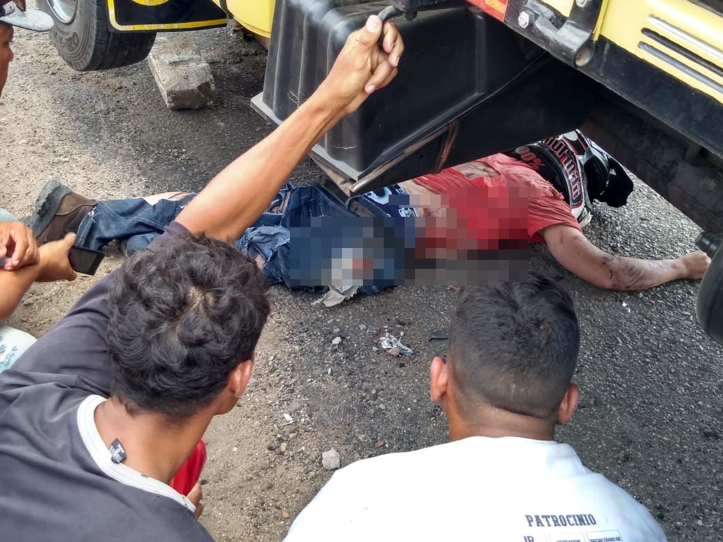 Motoqueiro ficou ferido em baixo do caminhão. (Foto: reprodução/whatsapp)